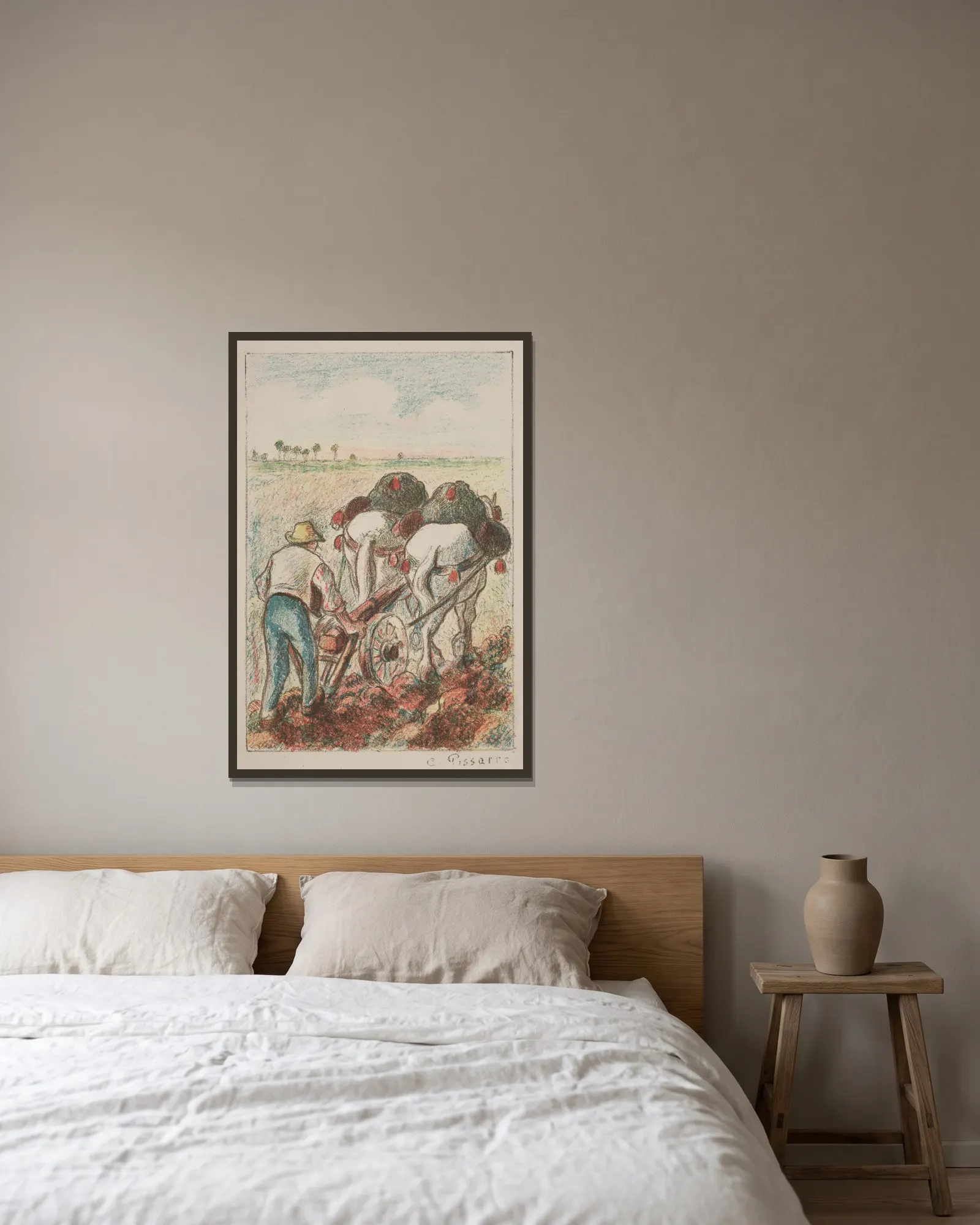 La Charrue av Camille Pissarro inramad på en vägg